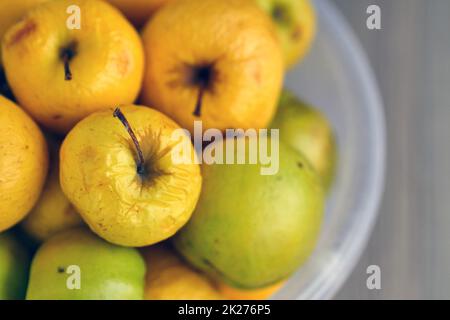 Verrottende gelbe Äpfel, geschrumpfte Äpfel, die schon lange in einer Schüssel standen Stockfoto