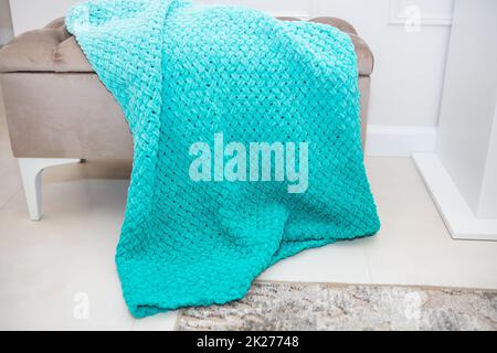 Hintergrundstruktur aus Plüschgewebe in aquamaringrüner Farbe, Hintergrundmuster aus weichem Wollmaterial auf einem kleinen Sofa, gemütliches Konzept. Stockfoto