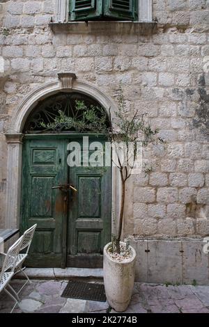 Kotor, 3. Juli 2021: Wunderschöne Straßen in der Altstadt von Kotor, grüne alte Türen, Montenegro. Stockfoto