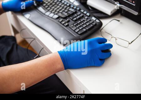 Ein Arzt in blauen Handschuhen sammelt schnell Daten über einen Patienten. Das Konzept des Gesundheitswesens und der Pflege Ihrer Gesundheit. Arbeitsplatz eines Arztes, Online-Beratung. Stockfoto