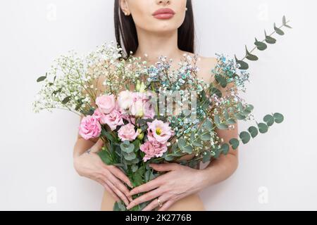 Die Hände des Mädchens halten einen sehr schönen Frühlingsstrauß voller Blumen: Rosa Eustoma, mehrfarbige Zigeuner, Eukalyptus. Blütenzusammensetzung. Frühling, 8. März. Stockfoto