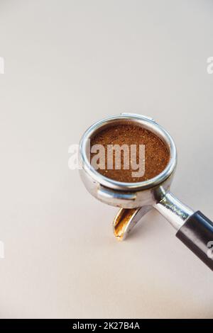 Portafilter mit gemahlenem Kaffee auf hellgrauem Hintergrund. Der Blick von oben. Stockfoto