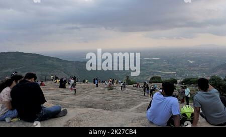 Nandi Hills, Karnataka, Indien-Mai 22 2022: Touristen genießen den wunderschönen Sonnenuntergang von der Spitze der Nandi Betta oder Nandidurg. Top Picknickplatz und Woche Stockfoto