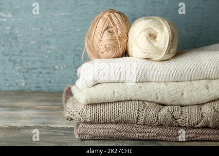 Stricken Kleidung und Garn auf Holz- Hintergrund Stockfoto