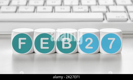 Buchstabenwürfel vor einer Tastatur - Februar 27 Stockfoto