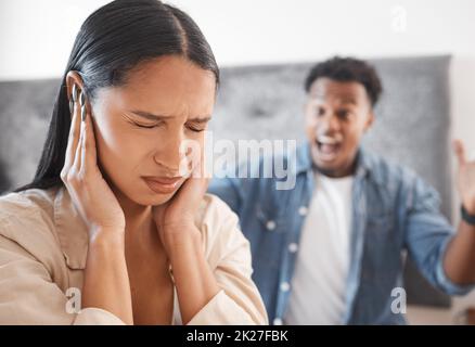 Frau erschreckt, Lärm und Missbrauch von wütenden Mann im Wohnzimmer zu Hause. Angst, Mobbing und traurige Frau bedecken die Ohren, während der Ehemann schreit oder anschreit Stockfoto