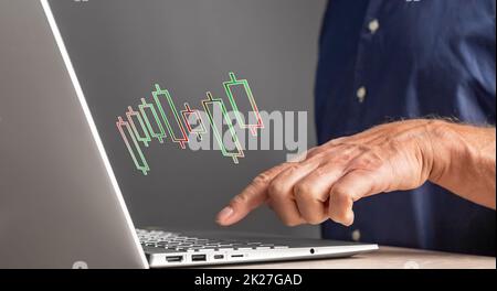 Mann, der mit einem Candlestick-Chart auf dem Laptop arbeitet. Aktienmarktanalyse. Finanz-, Investitions-, Handelskonzept. Geschäftsmann analysiert die Preisbewegung. Nahaufnahme des männlichen Zeigefingers auf der Tastatur. Hochwertige Fotos Stockfoto