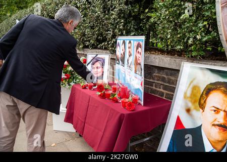 London, Großbritannien. 22. September 2022. Iraner in London protestieren vor der iranischen Botschaft, 16 Prince's Gate, London, SW7 1pt, gegen den Tod von Mahsa Amini. Rote Rosen auf einem Gedenktafel mit einem Foto von Mahsa Amini, auch bekannt als Jina Amini kurdischen Erbes, der jungen Frau, die während der Haft der Moralpolizei im Iran wegen eines angeblichen Verstoßes gegen die Vergeltung des Hijabs starb. Kredit: Peter Hogan/Alamy Live Nachrichten Stockfoto