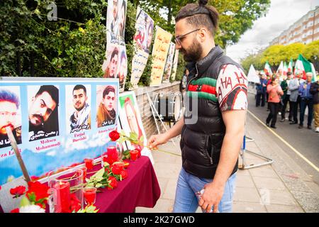 London, Großbritannien. 22. September 2022. Iraner in London protestieren vor der iranischen Botschaft, 16 Prince's Gate, London, SW7 1pt, gegen den Tod von Mahsa Amini. Rote Rosen auf einem Gedenktafel mit einem Foto von Mahsa Amini, auch bekannt als Jina Amini kurdischen Erbes, der jungen Frau, die während der Haft der Moralpolizei im Iran wegen eines angeblichen Verstoßes gegen die Vergeltung des Hijabs starb. Kredit: Peter Hogan/Alamy Live Nachrichten Stockfoto