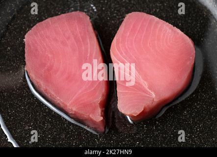 Rohe Thunfischsteaks auf einer Bratpfanne aus Metall. Nahaufnahme. Stockfoto