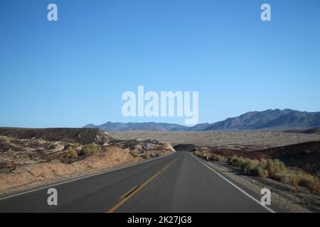 Death Valley Straße durch die Wüste zu den Bergen in der Ferne Stockfoto