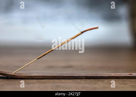 Begriff des langsamen Lebens und Achtsamkeit. Aromatischer Saldanholz-Weihrauch-Schwelstab. Brennende Kerze. Aromatherapie-Praxis. Frieden und Ruhe finden. Spirituelles Ritual zu Hause Stockfoto