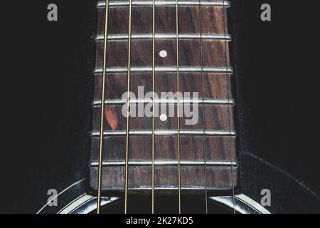 Akustik-Gitarrensaiten werden näher betrachtet. Musikinstrument Stockfoto