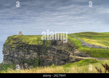 Massen von Touristen, die über Treppen zum OBriens Tower auf den berühmten Cliffs of Moher, Irland, laufen Stockfoto