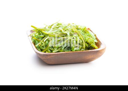 Grünes Wachspiel. Algensalat in Holzschüssel isoliert auf weißem Hintergrund. Stockfoto