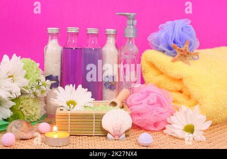 Bad- und Wellnessprodukte mit Blumen auf rosafarbener Seife Stockfoto