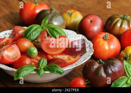 Bunte Tomaten Salat mit Basilikum und Balsamico auf Holz rustikale Hintergrund Stockfoto