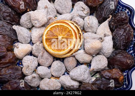 Getrocknete Orangenscheiben, mit Reismehl bestreute Feigen und Medjoul-Jumbo-Datteln. Stockfoto