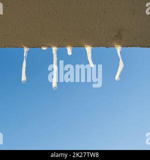 Eiszapfen beim Blick aus dem Fenster eines Hauses im Winter Stockfoto