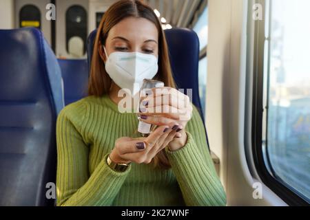 Geschäftsfrau mit medizinischer Gesichtsmaske mit Alkohol-Gel-Desinfektionsmittel Hände auf öffentlichen Verkehrsmitteln. Antiseptikum, Hygiene und Gesundheitskonzept. Konzentriere dich auf die Hand. Stockfoto