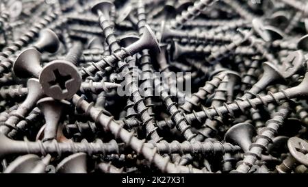 Stahlschrauben, Metallschrauben, Eisenschrauben, Schrauben als Hintergrund, Holzschrauben. Schraubnägel aus Eisen oder Metall stapeln den Hintergrund der Industriebauindustrie. Stockfoto