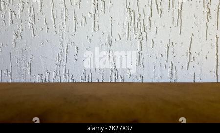 Leere Oberseite eines Tischs aus natürlichem Holz und dekorative Wand in Retro-Weiß. Um das Produkt anzuzeigen. Holztisch und weiße Wand. Leere Tischplatte aus Holz, Theke, Regal in der Wand des Raums Stockfoto