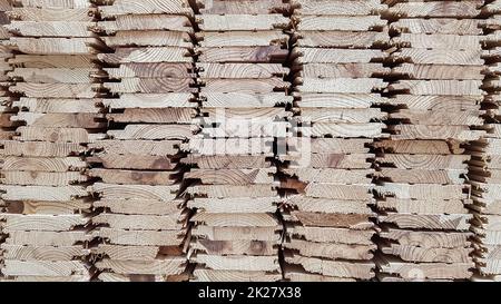 Ein Stapel neuer Holzbretter auf Lager. Produktionslinie einer Fabrik mit Holzböden. Industrieller Hintergrund Stockfoto