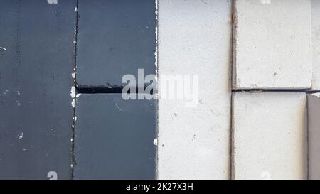 Schwarze und weiße Ziegel stapeln sich gleichmäßig auf einem Stapel. Nahaufnahme. Schwarz-weißer Steinhintergrund Stockfoto