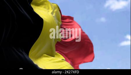 Detail der Nationalflagge Belgiens, die an einem klaren Tag im Wind winkt Stockfoto