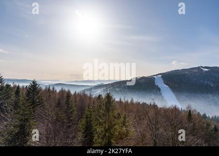 Nebliger Blick auf die Bergkette Beskid Sadecki an einem sonnigen Tag Stockfoto