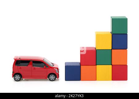 Kleines Spielzeugauto und bunte Holzbausteine auf weißem Hintergrund Stockfoto