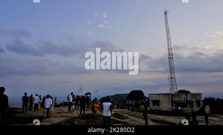 Nandi Hills, Karnataka, Indien-Mai 22 2022: Touristen genießen den wunderschönen Sonnenuntergang von der Spitze der Nandi Betta oder Nandidurg. Top Picknickplatz und Woche Stockfoto