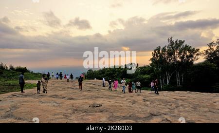 Nandi Hills, Karnataka, Indien-Mai 22 2022: Touristen genießen den wunderschönen Sonnenuntergang von der Spitze der Nandi Betta oder Nandidurg. Top Picknickplatz und Woche Stockfoto