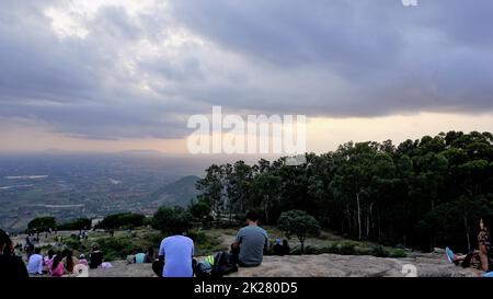 Nandi Hills, Karnataka, Indien-Mai 22 2022: Touristen genießen den wunderschönen Sonnenuntergang von der Spitze der Nandi Betta oder Nandidurg. Top Picknickplatz und Woche Stockfoto