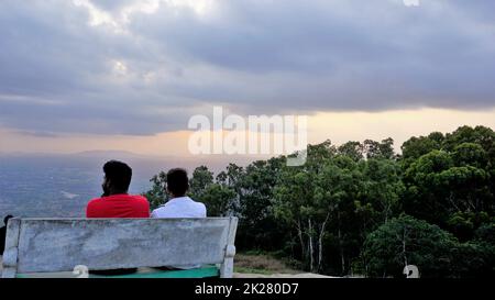 Nandi Hills, Karnataka, Indien-Mai 22 2022: Touristen genießen den wunderschönen Sonnenuntergang von der Spitze der Nandi Betta oder Nandidurg. Top Picknickplatz und Woche Stockfoto