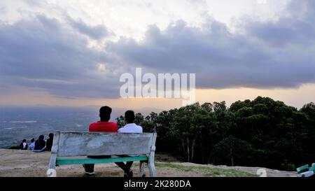 Nandi Hills, Karnataka, Indien-Mai 22 2022: Touristen genießen den wunderschönen Sonnenuntergang von der Spitze der Nandi Betta oder Nandidurg. Top Picknickplatz und Woche Stockfoto