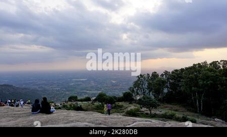 Nandi Hills, Karnataka, Indien-Mai 22 2022: Touristen genießen den wunderschönen Sonnenuntergang von der Spitze der Nandi Betta oder Nandidurg. Top Picknickplatz und Woche Stockfoto