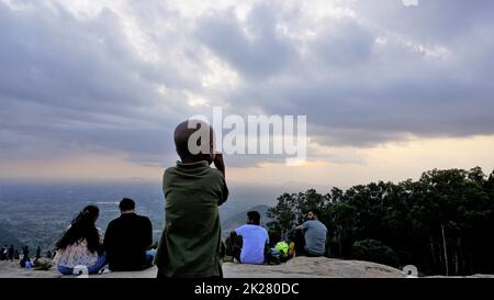 Nandi Hills, Karnataka, Indien-Mai 22 2022: Touristen genießen den wunderschönen Sonnenuntergang von der Spitze der Nandi Betta oder Nandidurg. Top Picknickplatz und Woche Stockfoto