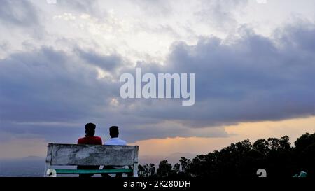 Nandi Hills, Karnataka, Indien-Mai 22 2022: Touristen genießen den wunderschönen Sonnenuntergang von der Spitze der Nandi Betta oder Nandidurg. Top Picknickplatz und Woche Stockfoto