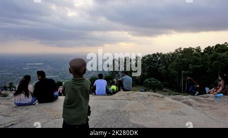 Nandi Hills, Karnataka, Indien-Mai 22 2022: Touristen genießen den wunderschönen Sonnenuntergang von der Spitze der Nandi Betta oder Nandidurg. Top Picknickplatz und Woche Stockfoto