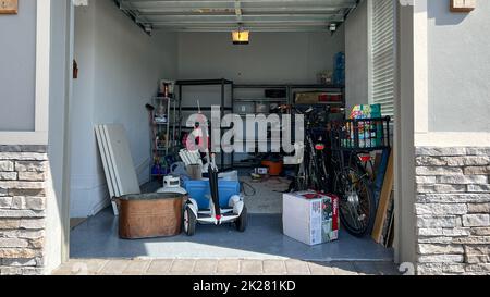 Orlando, FL USA - 3. März 2022: Eine unorganisierte Garage voller Sachen in einer Nachbarschaft. Stockfoto