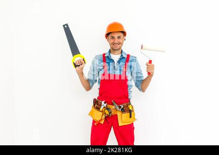 Junger freundlicher, auf Weiß isolierter, hockender Arbeiter Stockfoto