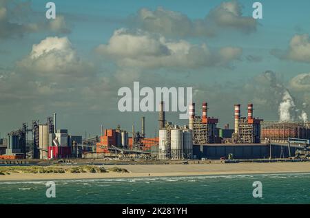 Europa, Frankreich, Dunkerque - 9. Juli 2022: Hafenlandschaft. Gas- und Kohlekraftwerk am Energiedock mit Kraftwerk unter blauer Wolkenlandschaft. Azure Stockfoto