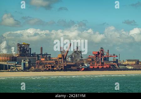 Europa, Frankreich, Dunkerque - 9. Juli 2022: Hafenlandschaft. Nahaufnahme, Kohlenterminal am Energy Dock mit Kraftwerk unter blauer Wolkenlandschaft. Azure Stockfoto