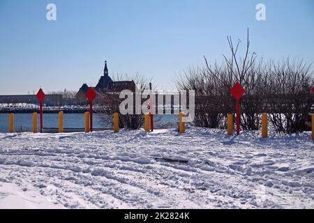 Rote Schilder am Ende der Straße mit Schnee auf dem Boden und Central Railroad of New Jersey Terminal auf der Rückseite Stockfoto