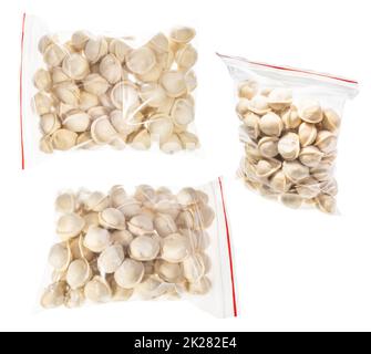 Set aus gefrorenem Pelmeni in Kunststoffbeuteln isoliert Stockfoto
