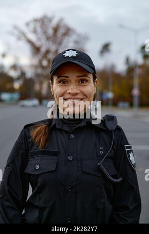 Porträt einer lächelnden Polizistin auf der Straße Stockfoto