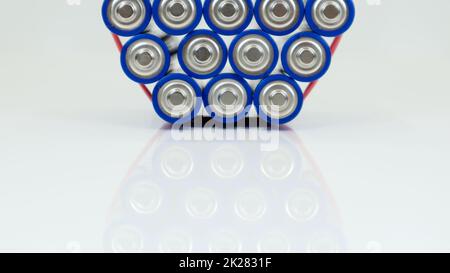 Viele AA- und AAA-Alkali-Batterien auf weißem Hintergrund. Ökologisches Recyclingkonzept. Die Anschlüsse der Einwegbatterien liegen dicht beieinander und bilden eine schöne Kulisse. Energiequelle. Stockfoto