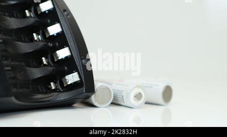 Schnellladegerät für vier AA-Akkus in Schwarz auf weißem Hintergrund. Keine Batterien. Stockfoto