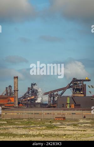 Europa, Frankreich, Dunkerque - 9. Juli 2022: Hafenlandschaft. Nahaufnahme des Kohleumlaufgürtels im Kraftwerk unter rauchigen Himmel. Großes Lager und Stockfoto